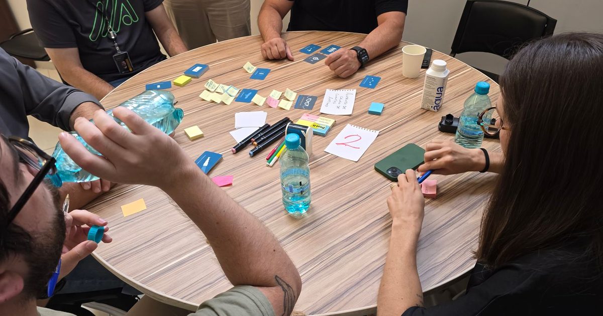 Collaborateurs autour d'une table lors d'un atelier de cohésion d'équipe avec cartes et post-it